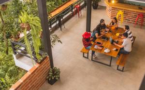 a group of people sitting at tables in a restaurant at Margarit Boutique Hotel in Mindo