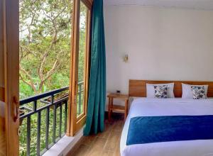 a bedroom with a bed and a large window at Margarit Boutique Hotel in Mindo