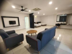 ein Wohnzimmer mit einem blauen Sofa und einem Tisch in der Unterkunft 20Pax 3-Storey SemiD 5Room&5Bathroom Sweet Dream Home Sitiawan in Sitiawan
