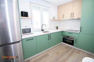 uma cozinha com armários verdes e um lavatório em APARTAMENTO COMPLETO SAN FRANCISCO em Santiago de Compostela