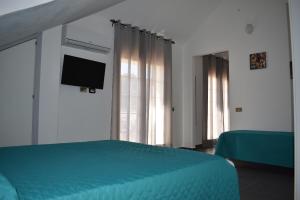 a bedroom with a bed and a flat screen tv at Villa Le Ninfee in Menfi