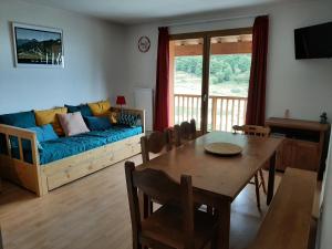 a living room with a blue couch and a table at GUZET-Pyrénées-Pied des pistes in Ustou