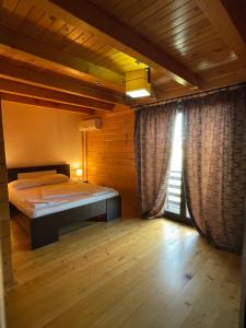 a bedroom with a bed in a room with wooden walls at Natalice By The Sea in Costinesti