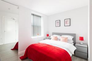ein weißes Schlafzimmer mit einem roten und weißen Bett in der Unterkunft Hagley Road Apartments - Self Contained Entire Apartments with Kitchen & Netflix - Birmingham City Centre in Birmingham
