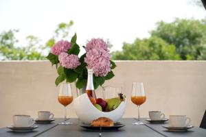 a table with a vase of flowers and a bowl of fruit at Apartment Twins in Šibenik