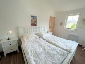 - un lit blanc dans une chambre avec fenêtre dans l'établissement Strandpark Sierksdorf H049, à Sierksdorf