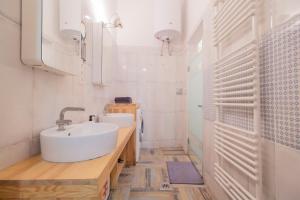 Baño blanco con lavabo y aseo en Industrial Double Loft Apartment, en Budapest