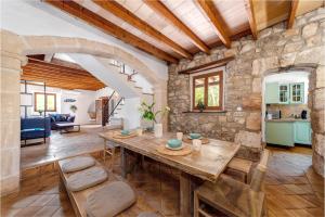 a living room with a wooden table and a stone wall at Borgata Roggio in Sineu