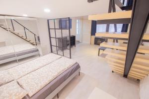 sypialnia z 2 łóżkami piętrowymi i schodami w obiekcie Industrial Double Loft Apartment w Budapeszcie