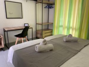Dos camas en una habitación con toallas. en Georgina en Agia Marina Aegina