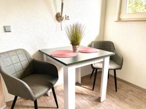 a table with two chairs and a potted plant on it at Zuhause im Ruhrgebiet 2 mit Balkon in Oberhausen