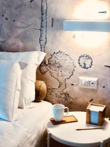 洛伊里聖保洛的住宿－Il Borgo Boutique Rooms by KasaVacanze，一张床上,桌上放着一杯咖啡