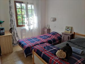 ein Schlafzimmer mit 2 Betten und einem Teddybär auf dem Bett in der Unterkunft Grande maison avec grande piscine in Pont-Saint-Esprit