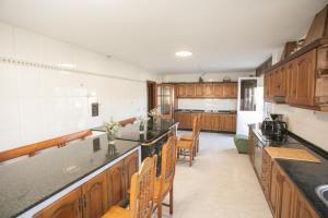 a kitchen with wooden cabinets and a counter top at Pensión Lobre in O Pedrouzo