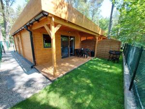 a small wooden cabin with a table in a yard at Toscana Camp in Pogorzelica