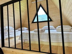 twee bedden in een kamer met een raam bij Thomas' Hut in Kazbegi