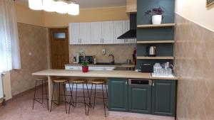 a kitchen with green cabinets and a counter with stools at Pension Casa Maria in Sovata