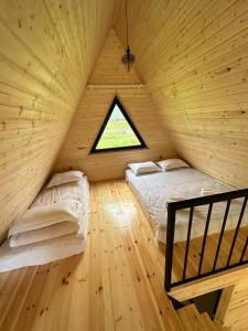 een slaapkamer met 2 bedden in een houten huis bij Thomas' Hut in Kazbegi
