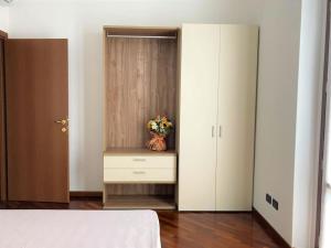 a bedroom with a dresser with a vase of flowers on it at Appartamento Dante in Cremona