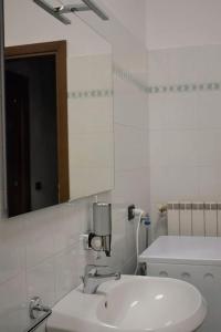 ein weißes Badezimmer mit einem Waschbecken und einem Spiegel in der Unterkunft Appartamento Dante in Cremona