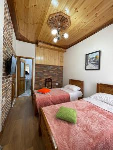 a room with two beds and a tv in it at As e vogël, As e madhe in Ersekë