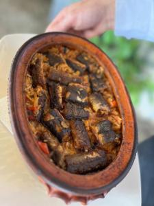 a person holding a bowl of food at Apartmani Konoba Starčevo in Virpazar