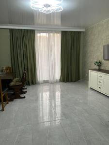 a large living room with a chandelier and green curtains at villa with beautiful view 2 in Tbilisi City