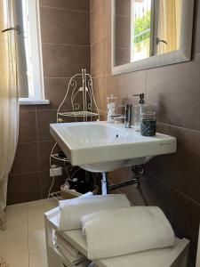 ein Bad mit einem Waschbecken und einem Spiegel in der Unterkunft Casa Vacanze Randelli in Ameglia