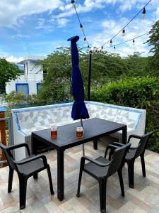 a table with chairs and a blue umbrella on a patio at Casa vacacional Carmen de apicala in Carmen de Apicalá