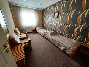 1 dormitorio con 2 camas, silla y ventana en Hotel SYLWANA, en Białe Błota