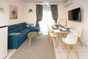 a living room with a blue couch and a table at Sunshine House in Skala Fourkas