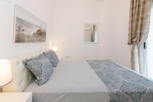 a white bed with blue pillows in a bedroom at Sunshine House in Skala Fourkas