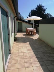 a patio with a table and an umbrella at Residenza Pastrengo in Pastrengo