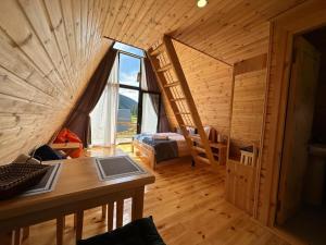 a room with a large window in a wooden cabin at Cozy Cottages in Mestia