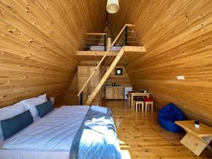 a bedroom with a bed in a wooden cabin at Cozy Cottages in Mestia