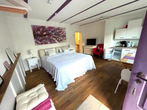 a bedroom with a white bed and a kitchen at Ferienhaus Maria in Walsdorf