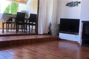 een woonkamer met een televisie en een tafel met stoelen bij Pals Playa 1era linea de mar, villa de golf in Begur