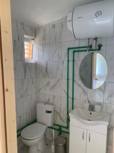 bagno con servizi igienici, lavandino e specchio di Gusinje View a Gusinje