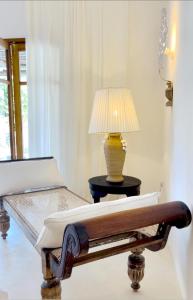 a lamp sitting on a table next to a bed at Simba Wa Kale Suites & Beach in Watamu