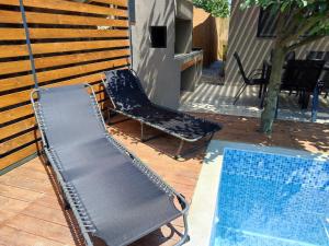 a bench and a swimming pool next to a house at mosquito Luxury Studio in Keramoti