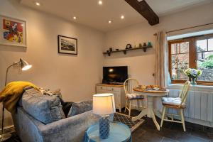 a living room with a couch and a table at Finest Retreats - Bamboo Cottage in Timberscombe