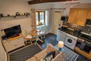 a living room with a table and a kitchen at Finest Retreats - Bamboo Cottage in Timberscombe