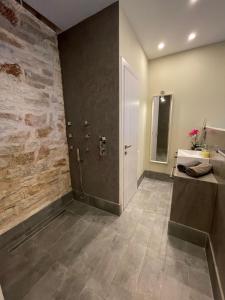 La salle de bains est pourvue d'un mur en pierre, d'un lavabo et d'une douche. dans l'établissement Luxury Villa set in Idyllic Cove, sunets, dolphins Nr Lefkada Villa Levanda, à Spartos