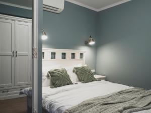 um quarto com uma grande cama branca com almofadas verdes em Stylish 1BD - Free Private Garage em Plovdiv