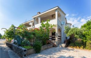 a white house with plants in front of it at 2 Bedroom Lovely Apartment In Pinezici in Pinezici