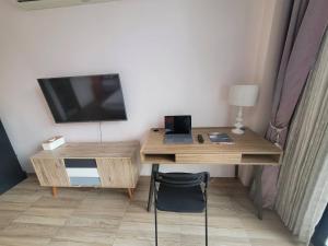 a desk with a television and a desk with a chair at THAI HOTEL CHIANGMAI in Chiang Mai