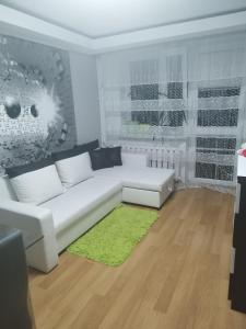 a living room with a white couch and a green rug at Vip apart 2 in Gorlice