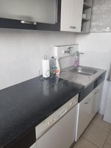 a kitchen with a sink and a black counter top at Vip apart 2 in Gorlice