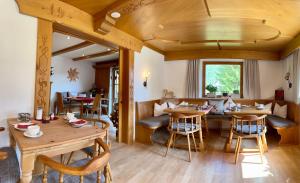 ein Esszimmer mit Holztischen und -stühlen in der Unterkunft Hotel Garni Gästehaus Edlhuber in Mittenwald