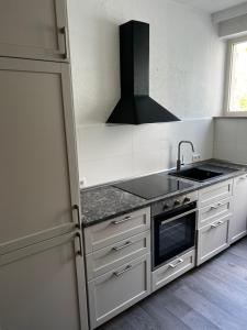 a kitchen with a sink and a stove at Hotel & Apartment Am Theaterplatz in Bremerhaven